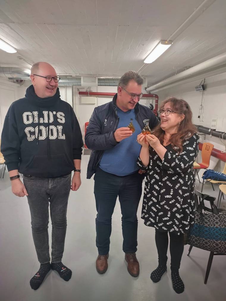 Kuvassa varapuheenjohtaja Timo Väisänen kiittä edellistä puheenjohtaja Marko Varjosta ja onnittelee uutta puheenjohtaja Mervi Valtasta täydellä pullollisella konjakkia 